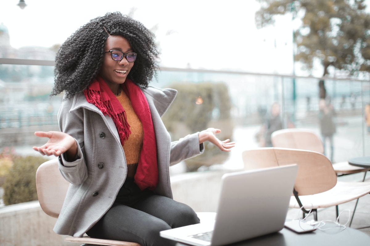 Woman sitting at computer with delighted expression on her face. 