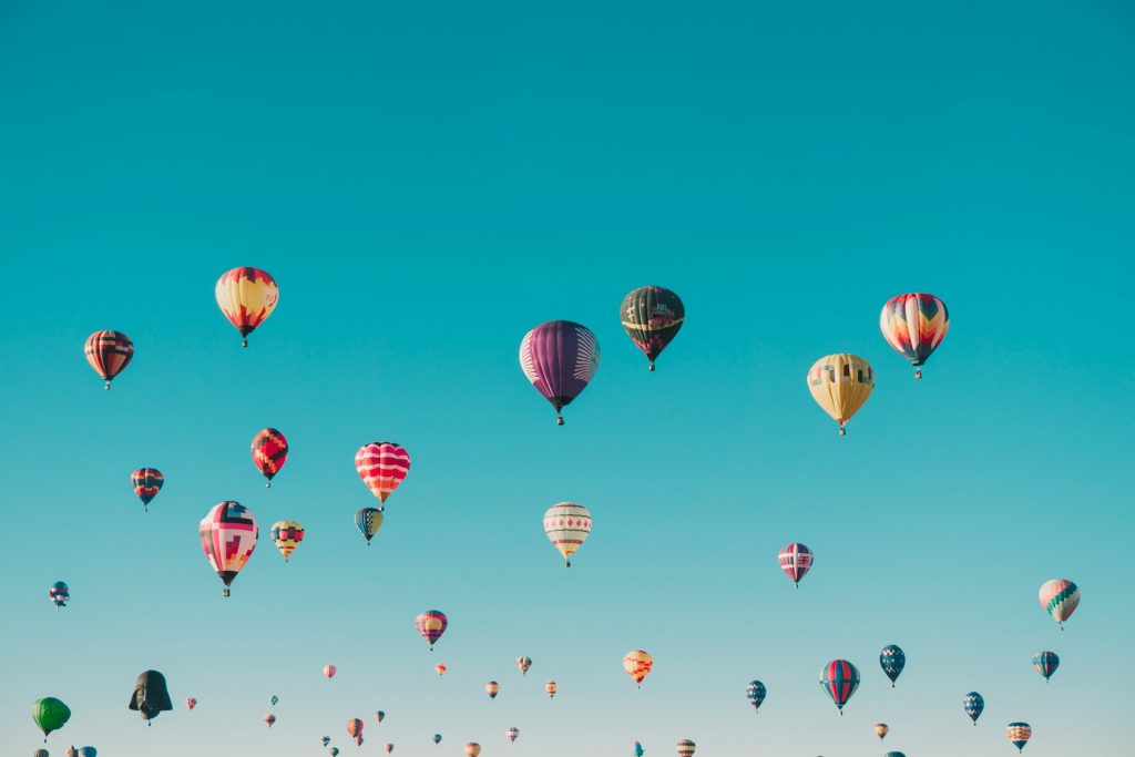 A large group of hot air balloons flying in the sky.