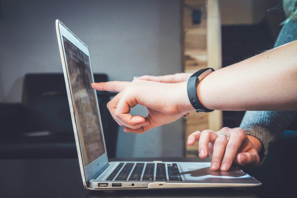 Behind the scenes of our influencer programs an image of people pointing to a laptop screen.