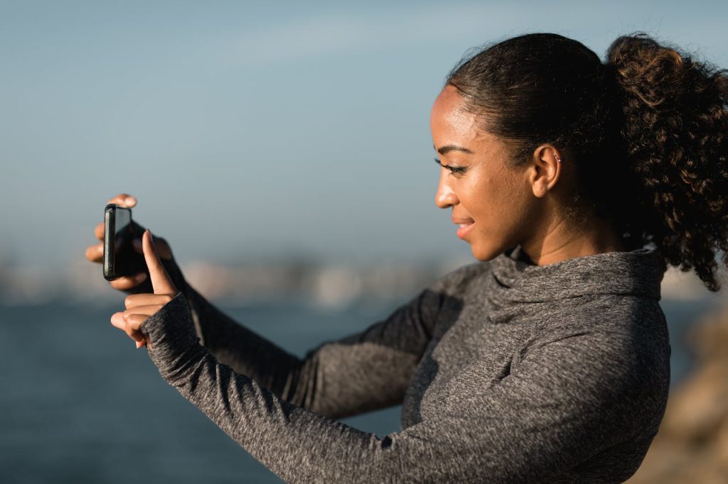 Woman outside with a phone creating lo-fi influencer content