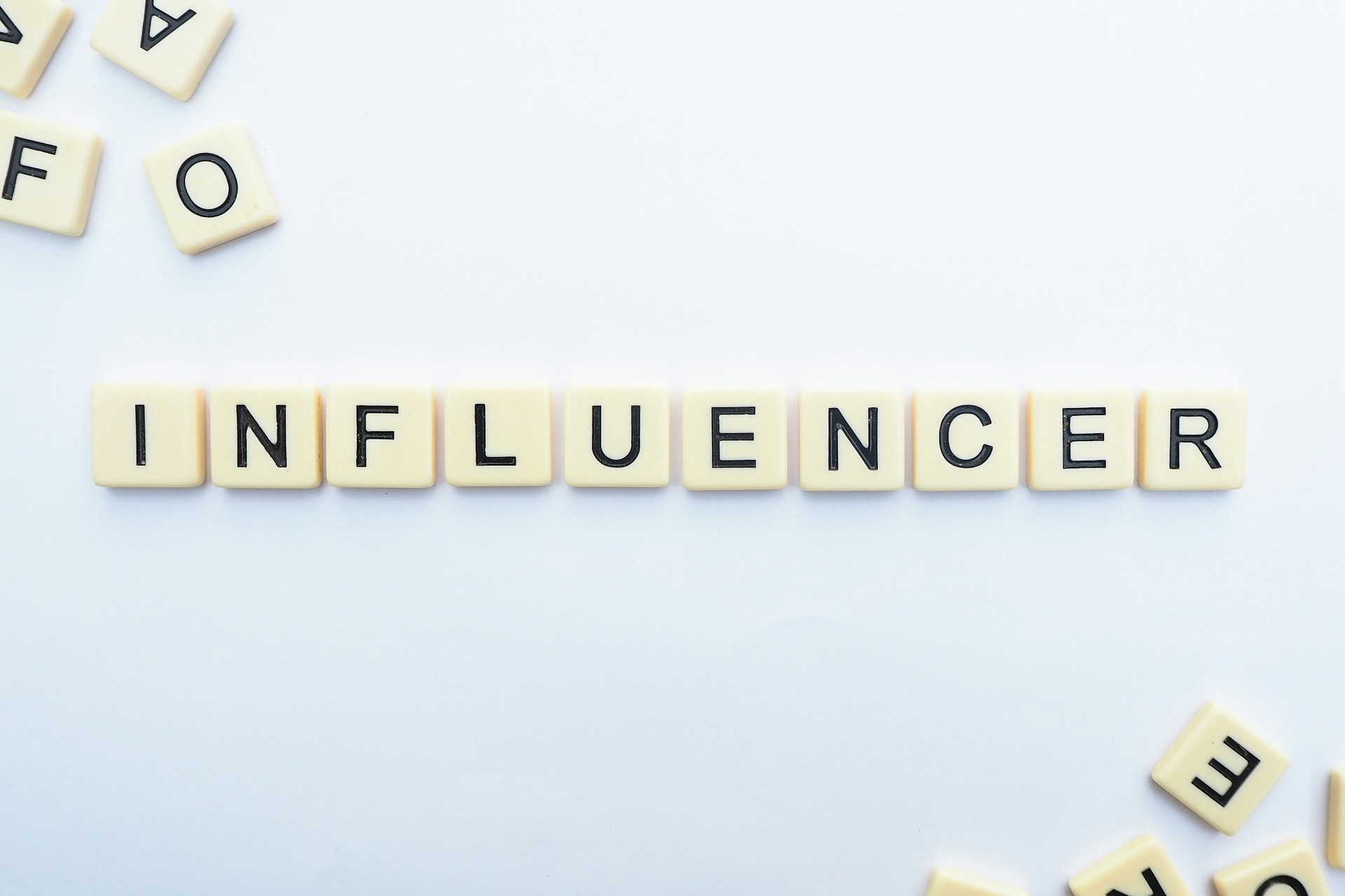 White tiles on a blue background spelling out the word "influencer" with other tiles showing slightly at the corners. 