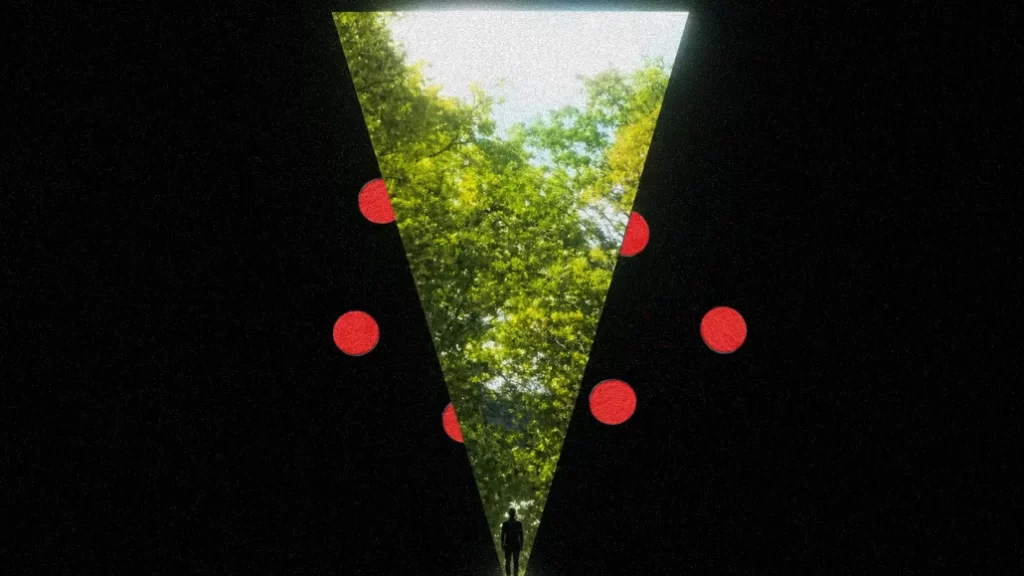 A black screen with some red dots split by a V-shape where the silhouette of a man is standing at the base of a large forest.